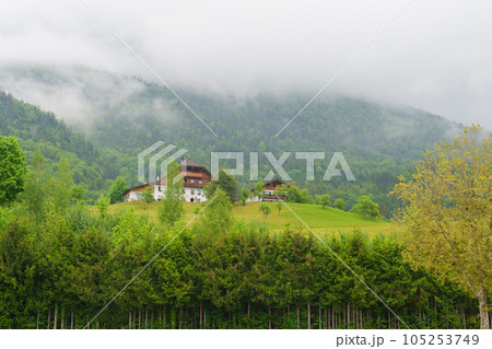 Wooden houses on the hillside. Clouds at the top of the mountain. Wooden houses on the hillside. Clouds at the top of the mountain. 105253749