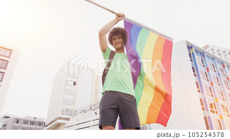 Smiling handsome young man with LGBT flag in his hands 105254378