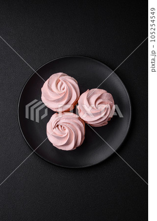 Delicious sweet colored marshmallow on a dark concrete background Delicious sweet colored marshmallow on a dark concrete background 105254549