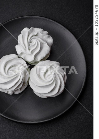 Delicious sweet colored marshmallow on a dark concrete background Delicious sweet colored marshmallow on a dark concrete background 105254678