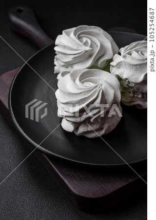 Delicious sweet colored marshmallow on a dark concrete background Delicious sweet colored marshmallow on a dark concrete background 105254687