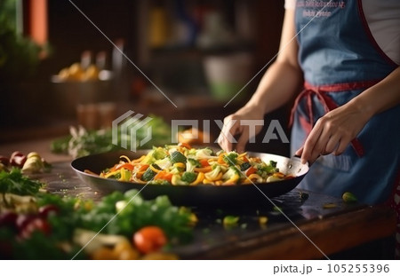 Stirring vegetables in a frying pan Stirring vegetables in a frying pan 105255396