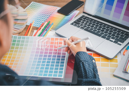 Graphic designer architects who work with laptops and color comparison tables for design work.. 105255509