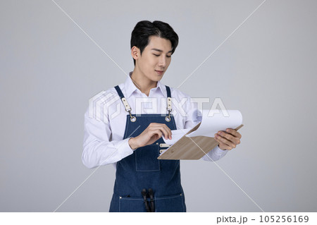 millennials and gen z, korean asian young man holding documents millennials and gen z, korean asian young man holding documents 105256169
