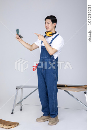 millennials and gen z, korean asian young man carpenter holding a bankbook millennials and gen z, korean asian young man carpenter holding a bankbook 105256253