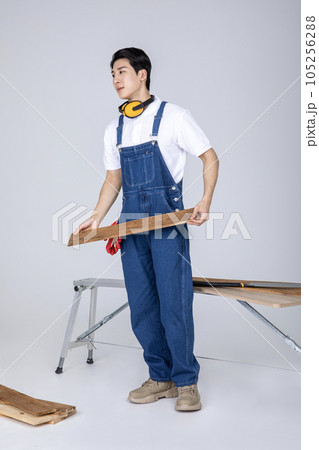 millennials and gen z, korean asian young man carpenter holding a board 105256288