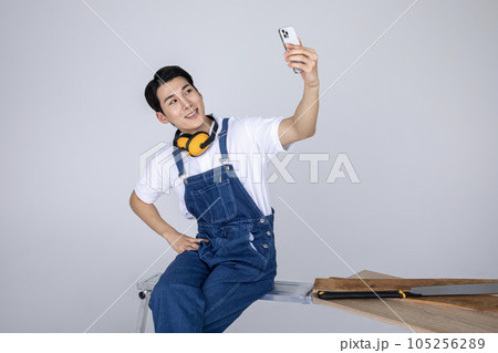millennials and gen z, korean asian young man carpenter taking selfie 105256289