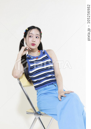 vintage y2k retro concept photo of korean asian cute woman sitting on a chair 105256982