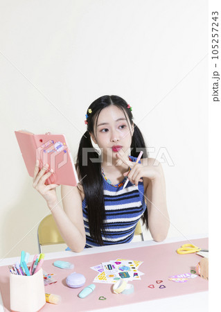 vintage y2k retro concept photo of korean asian cute woman with pen and diary 105257243