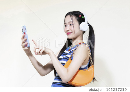vintage y2k retro concept photo of korean asian cute woman wearing a headphones and selecting music vintage y2k retro concept photo of korean asian cute woman wearing a headphones and selecting music 105257259