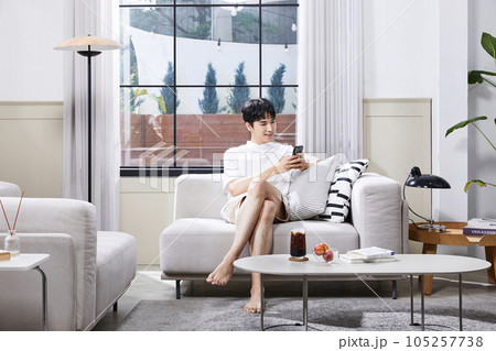 summer lifestyle, korean asian young man wtih couch and smartphone 105257738