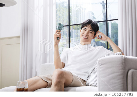 summer lifestyle, korean asian young man with handheld fan 105257792