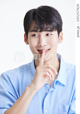 korean asian young man covering his mouth and laughing 105257920