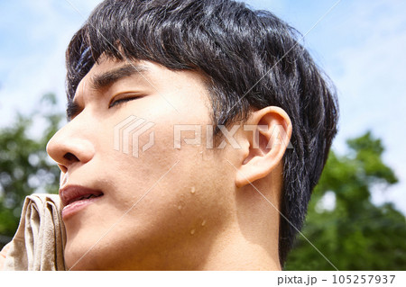 summer lifestyle, korean asian young man wiping sweat outdoor 105257937