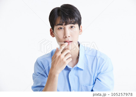 korean asian young man touching his lips and smiling korean asian young man touching his lips and smiling 105257978