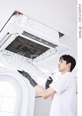 summer lifestyle, korean asian young man assembling air conditioner 105258054