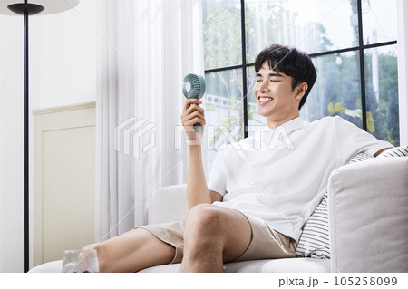 summer lifestyle, korean asian young man with handheld fan summer lifestyle, korean asian young man with handheld fan 105258099