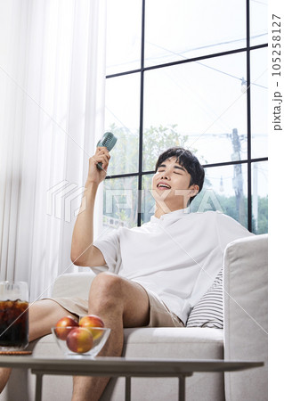 summer lifestyle, korean asian young man with handheld fan 105258127