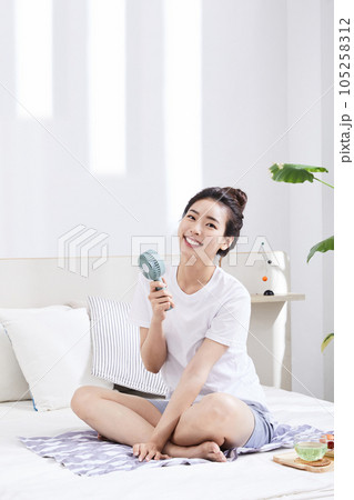 summer lifestyle, korean asian young woman with bed and fan summer lifestyle, korean asian young woman with bed and fan 105258312