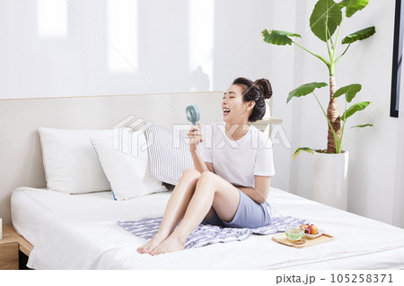 summer lifestyle, korean asian young woman with bed and fan summer lifestyle, korean asian young woman with bed and fan 105258371