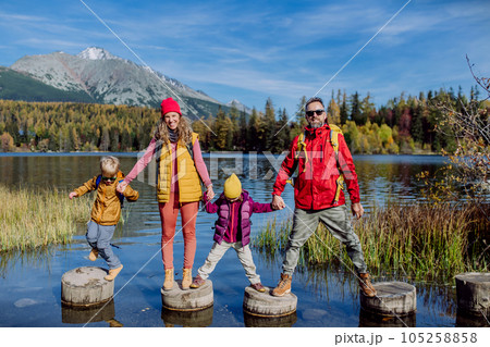 Happy young family with standing on wooden steps on the shore of the lake in mountains. Happy young family with standing on wooden steps on the shore of the lake in mountains. 105258858