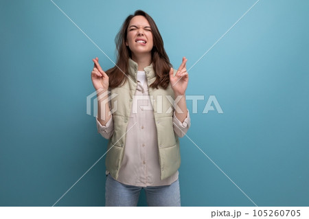 concentrated caucasian young brunette woman in casual clothes hopes on studio background 105260705