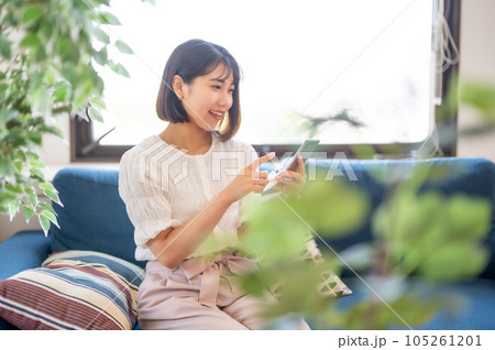 リビングでスマホを見る女性 105261201