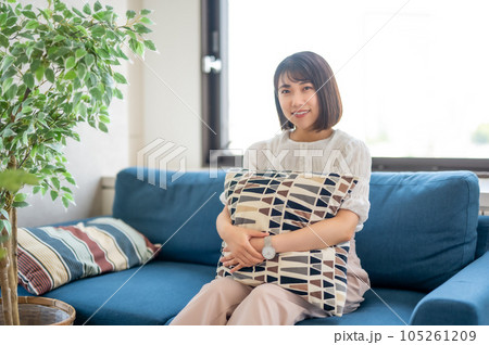 クッションを抱えてくつろぐ女性 105261209