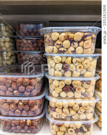 Peeled and unpeeled hazelnuts in plastic packages in the supermarket. 105261906