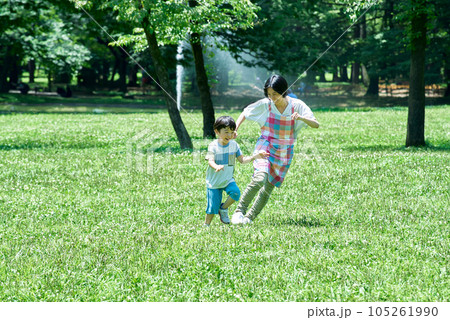 追いかけっこをして遊ぶ子供たちとエプロン姿の女性 追いかけっこをして遊ぶ子供たちとエプロン姿の女性 105261990