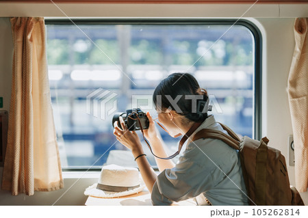 Asian teenage girl traveling using a camera take a photo to capture memories while waiting for a train at the station 105262814