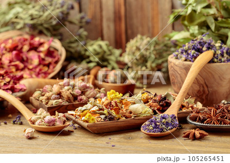 Various dried medicinal plants, herbs, and flowers on an old wooden background. 105265451