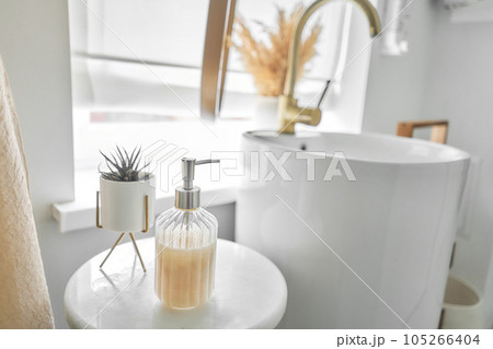 Eco friendly. Bottle of soap with dispenser places near assorted hygienic supplies on shelf in bathroom 105266404