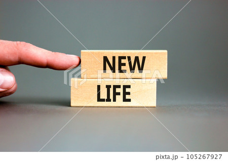 New life symbol. Concept words New life on wooden blocks on a beautiful grey table grey background. Businessman hand. Business, support, motivation, psychological and new life concept. Copy space. 105267927