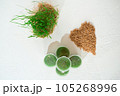 Juice and fresh wheat grass on the white table. 105268996