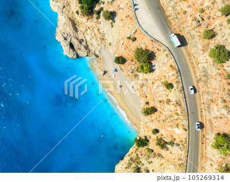 Aerial view of mountain road near blue sea, sandy beach at sunset Aerial view of mountain road near blue sea, sandy beach at sunset 105269314