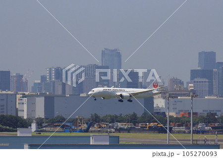 東京の都市を背景に着陸する旅客機　羽田空港に着陸する旅客機 105270093