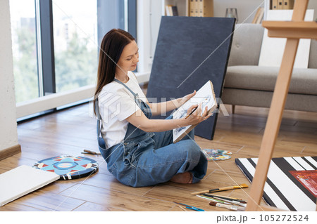 Focused lady working on new drawing at stylish home studio Focused lady working on new drawing at stylish home studio 105272524