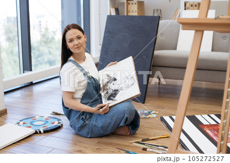 Artist demonstrating image of man on white canvas at home Artist demonstrating image of man on white canvas at home 105272527