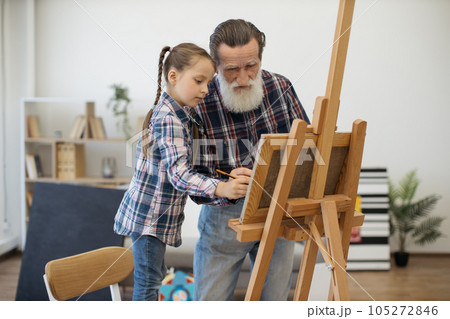 Grandpa teaching color combination rules to child in studio Grandpa teaching color combination rules to child in studio 105272846