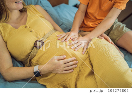 Young pregnant mother hugging her little boy lying in bed at night. Caring and loving parent hugging child Young pregnant mother hugging her little boy lying in bed at night. Caring and loving parent hugging child 105273803