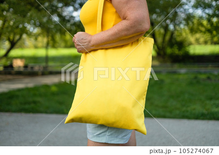 Woman is holding tote bag canvas fabric for mockup blank template. Woman is holding tote bag canvas fabric for mockup blank template. 105274067