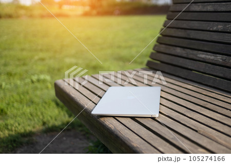 Laptop and nature. Laptop on a wooden table surrounded by forest. Close-up 105274166