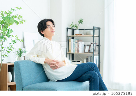 リビングでソファに座ってくつろぐ若い男性 105275195