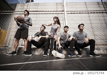 group of five asian young adults men and woman resting relaxing on outdoor basketball court group of five asian young adults men and woman resting relaxing on outdoor basketball court 105275744