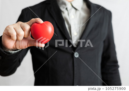 Businessman in suit holding red heart, healthcare, giving love, valentine and love festival concept 105275900