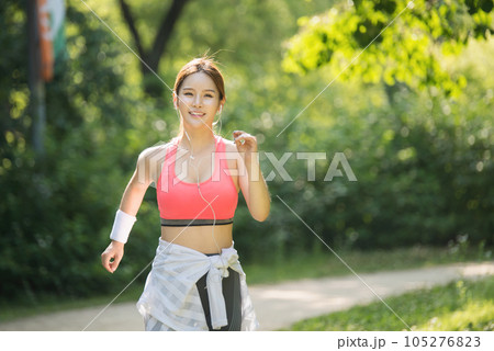 a young woman jogging in a sportswear in a summer morning park a young woman jogging in a sportswear in a summer morning park 105276823