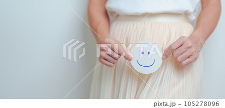 Woman hold Good and happy Face paper over abdomen. Ovarian and Cervical cancer, Endometriosis, Hysterectomy, Uterine, Reproductive, menstruation, Infertility, Pregnancy and Sexual Transmitted disease 105278096