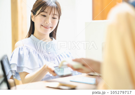 店舗でスマホ決済をする若い女性 105279717