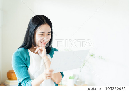 リビングで書類を見る女性 105280025